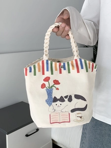 Close-up of canvas tote bag featuring cute cat illustrations and woven rope handles