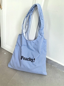 Close-up of blue and white striped nylon tote bag with Peachy! lettering print