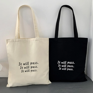Detailansicht robuster Canvas-Einkaufstaschen in Schwarz und Beige mit Buchstabendruck