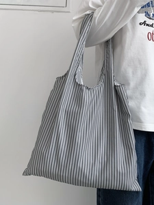 Détail du grand sac cabas à rayures verticales noires et blanches avec une grande capacité