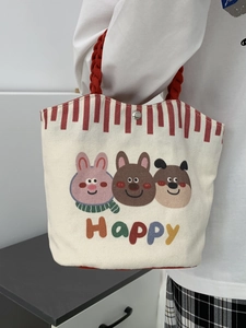 Detail of small canvas tote bag with cartoon animals and red striped trim