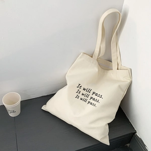 Detailansicht der weißen Canvas-Einkaufstasche mit schwarzem It will pass Textaufdruck