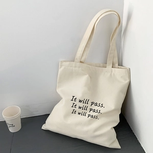 Detailansicht der cremefarbenen Canvas-Tasche mit minimalistischem Textaufdruck