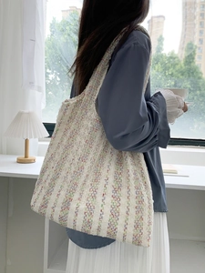 Close-up of the woven texture and colorful fiber details on a large white tote bag