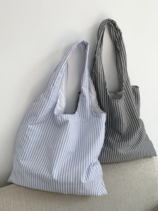 Détail de la texture du tissu rayé et des coutures d'un grand sac cabas fourre-tout