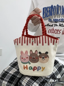 Close-up of small canvas tote bag with red rope handles and cute cartoon animal prints