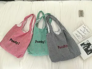 Close-up of three striped canvas tote bags with Peachy lettering in red, green and black