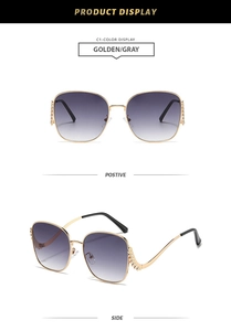 Detail of golden metal frame sunglasses featuring rhinestone accents on curved temples