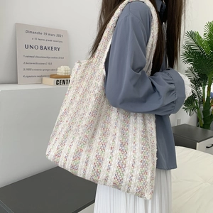 Detail of colorful knit canvas tote bag with textured knit fabric and wide shoulder strap