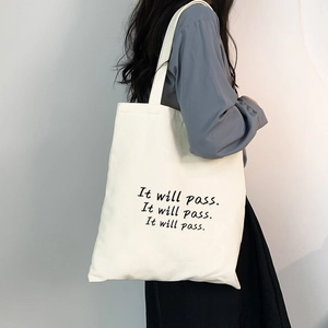 Detailaufnahme der weißen Segeltuchtasche mit minimalistischem 'It will pass' Aufdruck