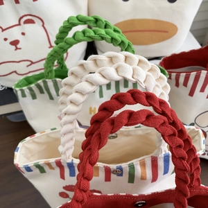 Close-up of thick woven cotton rope handles and metal snap closure on canvas bucket bags