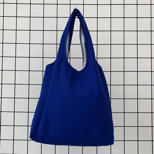 Close-up of deep blue canvas tote bag featuring reinforced stitching and inner lining detail