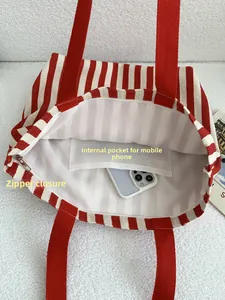 Detailed view of the striped canvas tote bag interior with zipper and phone pocket