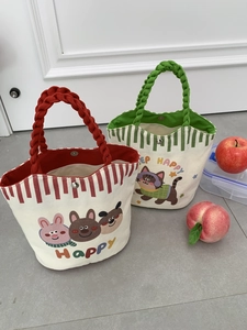 Detail of canvas lunch tote with cartoon prints, striped patterns and woven handles