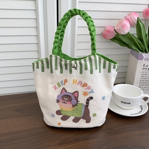 Detail of canvas bucket bag with cartoon cat print and green braided rope handle