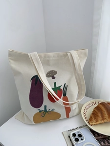 Dettaglio borsa tote in tela color crema con motivi di verdure e ampia capacità interna