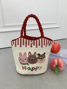 Detail of canvas tote bag with red handles, metal clasp and cute animal illustrations