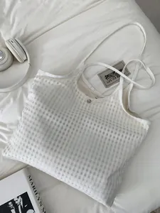 Detail of white mesh tote bag showing square texture and magnetic silver clasp