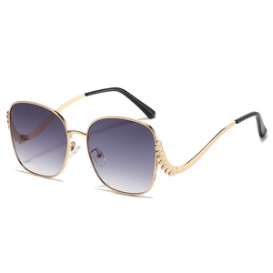 Gold oversized sunglasses with purple gradient lenses and rhinestone-encrusted temples