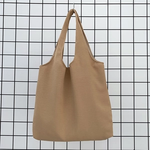 Close-up of khaki canvas tote bag showing thick textured fabric and sturdy stitching