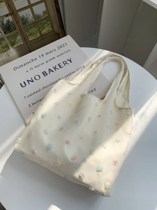 Close-up of elegant canvas tote bag with 3D floral embroidery and lace details