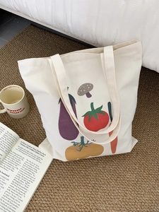 Dettaglio delle stampe vegetali su borsa tote in tela color crema con cuciture forti