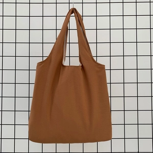 Close-up of caramel canvas tote bag showing thick fabric texture and seamless handles