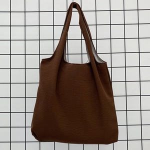 Detailed close-up of a dark brown canvas tote bag texture with inner lining and handle
