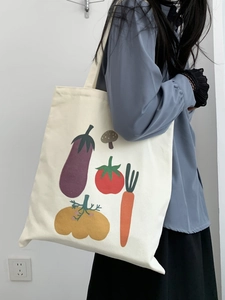 Dettaglio della borsa tote in tela con stampa vegetale indossata da una modella