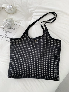 Detail of checkered mesh tote bag with metal snap button and breathable texture