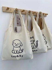 Vue détaillée de trois sacs cabas en toile minimalistes avec motifs animaux sur des crochets
