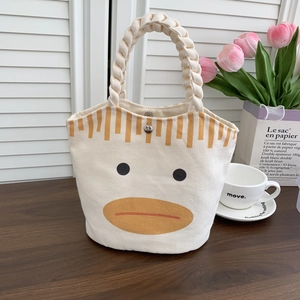 Detail of canvas bucket bag with braided rope handles and cute cartoon duck print