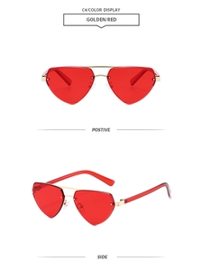Detail of red heart-shaped rimless sunglasses with golden metal bridge and temples