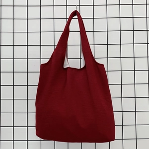 Detail of burgundy canvas tote bag showing durable cotton fabric texture and wide handle