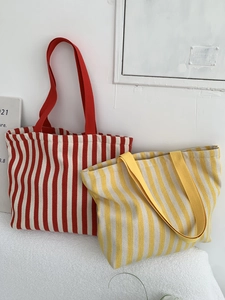 Detailed view of red and yellow striped canvas tote bags showing texture and handles