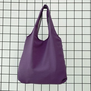 Detail of purple tote bag with crinkled nylon texture and reinforced stitched seams