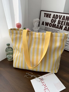 Detail of yellow striped canvas tote bag with thick fabric texture and handles