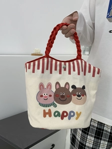 Small beige canvas tote bag with cartoon animal prints and red woven handles for daily use