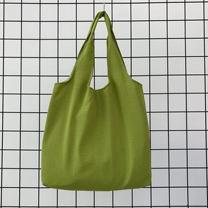Detail of a grass green canvas tote bag featuring premium woven fabric texture