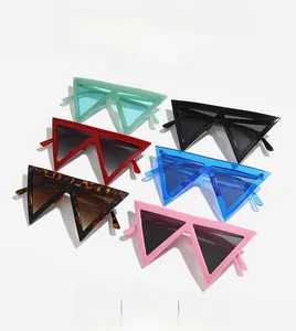 Flat lay of colorful geometric triangle sunglasses in mint green, black, red, and blue tones