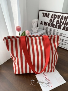 Detail of red and white striped canvas tote bag showing thick texture and wide strap