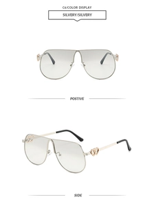 Detail view of silver pilot sunglasses featuring hollow heart motifs on the metal temples