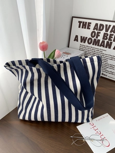 Detailed texture of blue striped canvas tote bag on a wooden table with decor