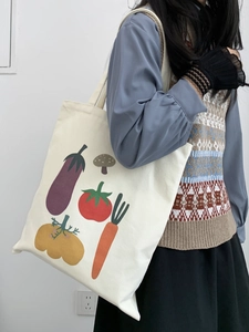 Dettaglio della borsa tote in tela con stampe di verdure carine indossata da una modella