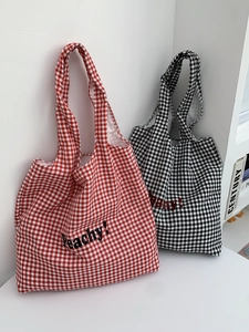 Detail of plaid canvas tote bag with Peachy text and sturdy shoulder straps