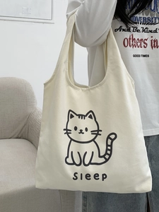 Détail du sac fourre-tout en toile blanc cassé avec motif chat épuré et large bandoulière