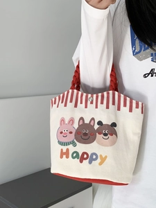 Detail of cartoon animal canvas tote with red braided rope handles and snap closure