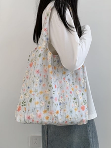 Gros plan d'un sac cabas en maille avec broderies florales montrant les détails et la texture