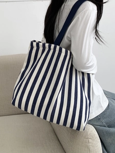 Detail of blue and white striped canvas tote bag showing the textured fabric and strap