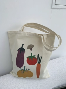 Dettaglio di una borsa tote in tela con stampe di verdure colorate disegnate a mano
